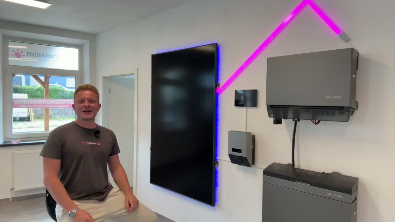 Samuel Rauscher im Mission-Solar-Showroom in Engstingen vor Solarmodul, Wechselrichter und Stromspeicher