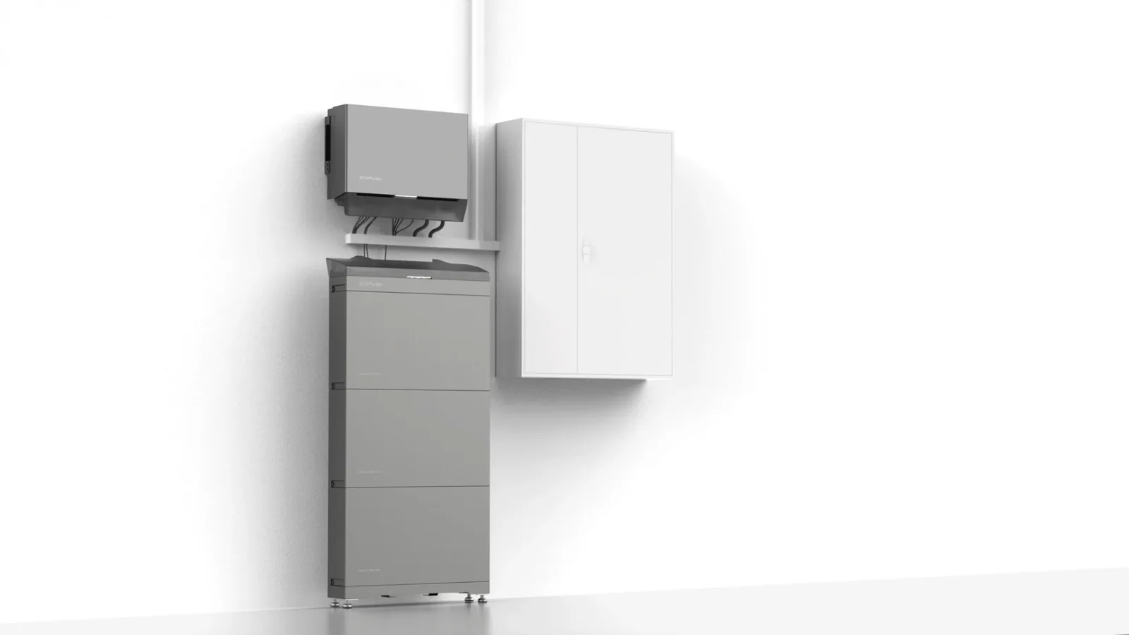 Wechselrichter und stehender Batteriespeicher sauber an einer weißen Wand neben einem Technikschrank installiert