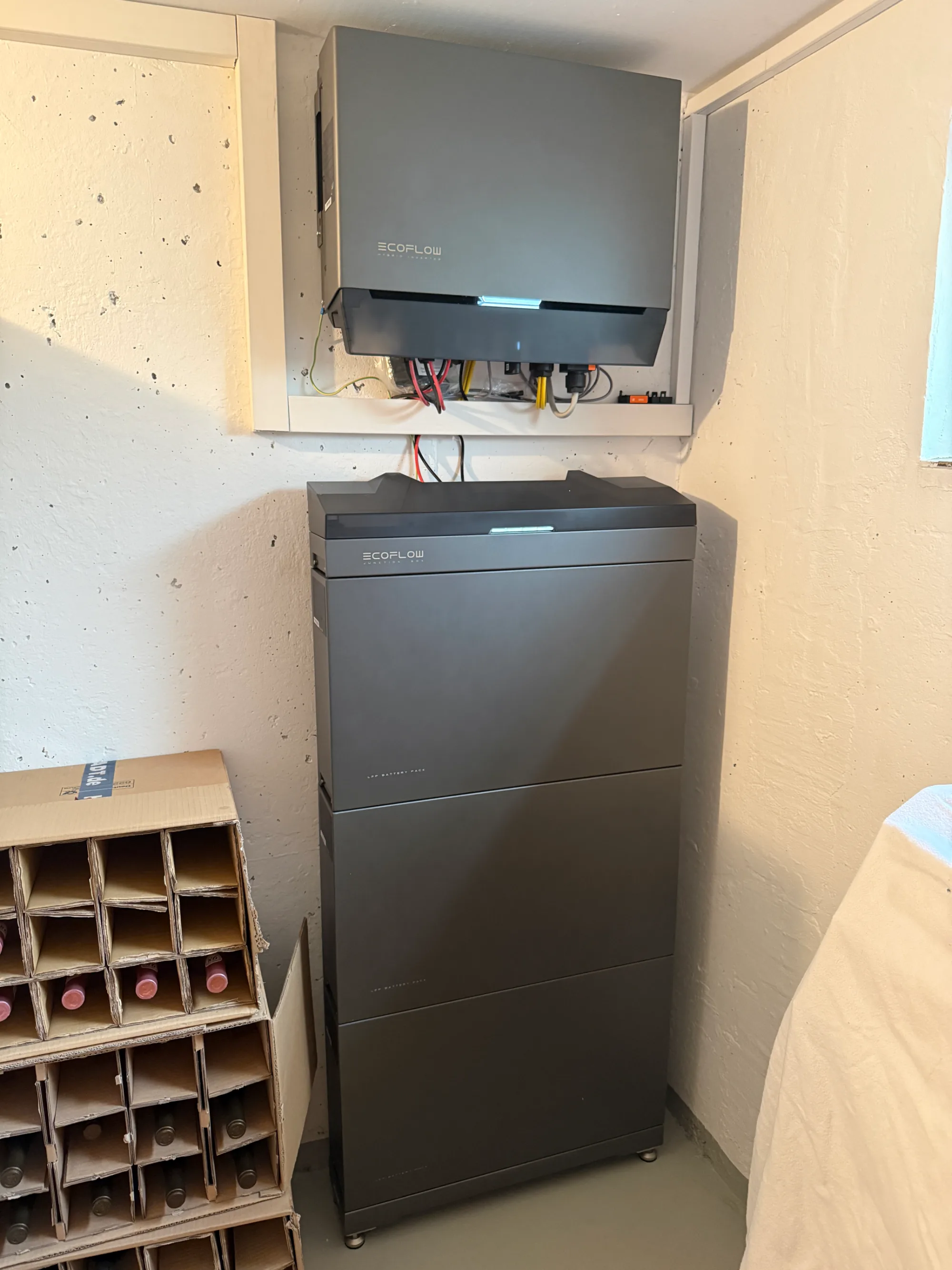 EcoFlow-Stromspeicher und passender Wechselrichter an der Wand in einem Kellerraum.