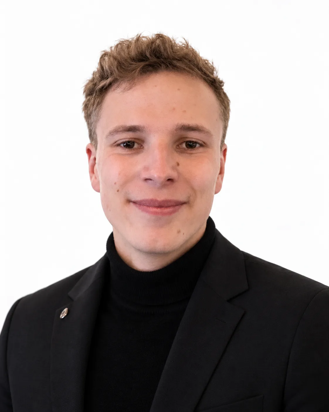 Porträt von Niclas Landau in dunklem Sakko vor weißem Hintergrund.